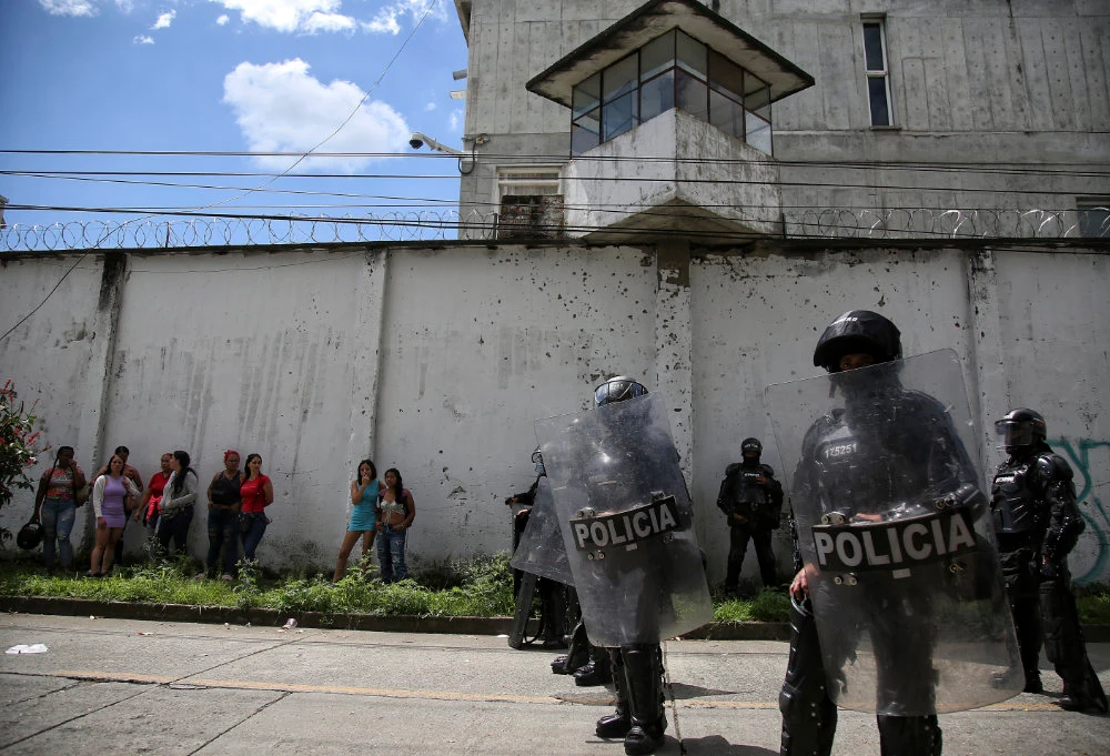 Police stand guard as inmates’ relatives gather outside a prison after there was a deadly fire in Tulua, Colombia, Tuesday, June 28, 2022. (AP)