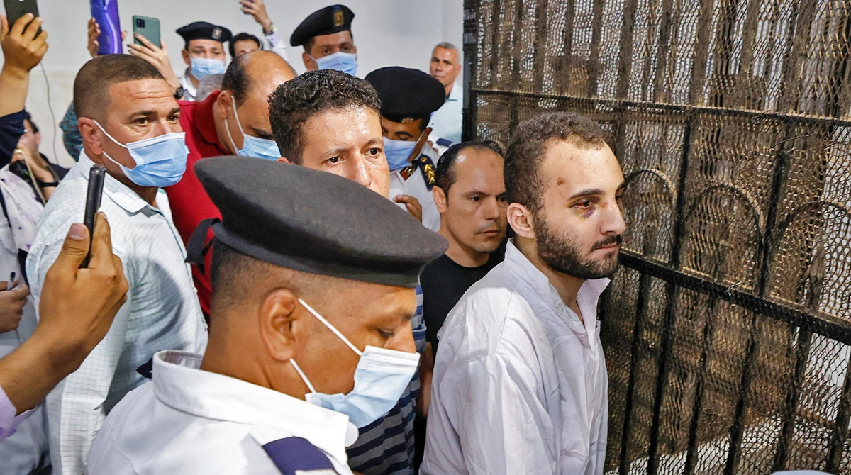 Mohamed Adel (C), the defendant in the murder of university of Mansoura student Naira Ashraf, is surrounded by guards during as he is taken out of the defender's box, some 145km north of Egypt's capital, on June 26, 2022. (AFP)