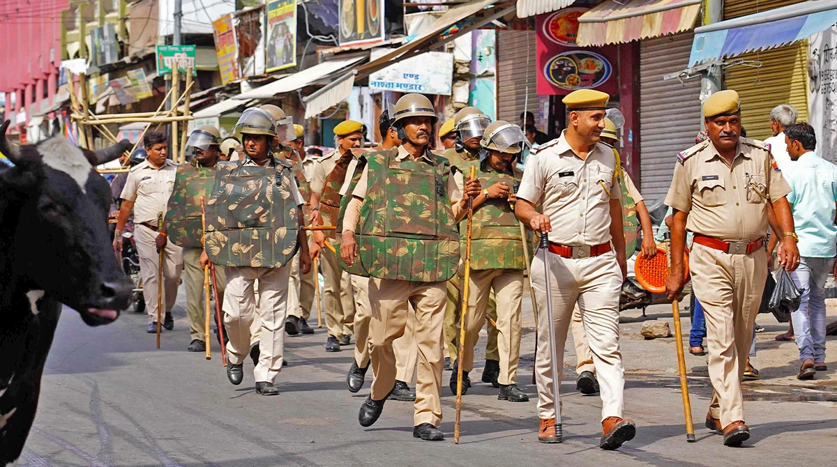 Policemen carry out a flag march through a street in Ajmer on June 29, 2022, following the alleged murder of a Hindu tailor by two Muslim men in Udaipur. (AFP)