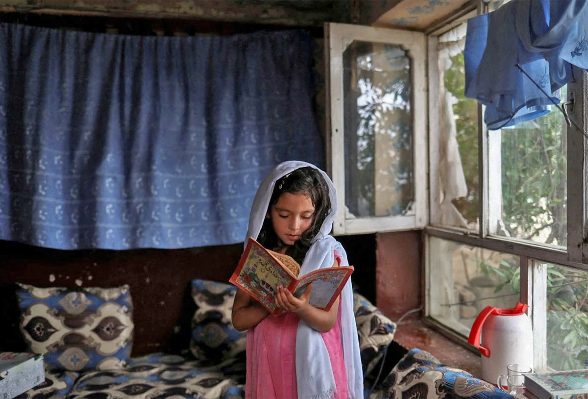 An Afghan girl reads a book inside her home in Kabul, Afghanistan, on June 13, 2022. (REUTERS/File)