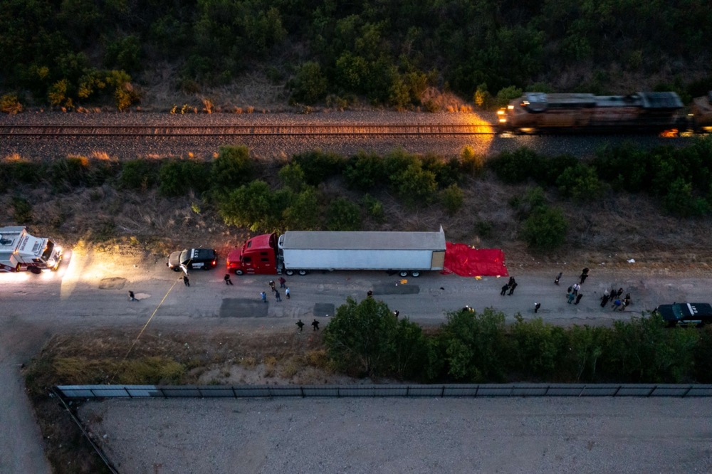 Members of law enforcement investigate a tractor trailer in San Antonio, Texas. 50 migrants died inside. (Getty Images/AFP)