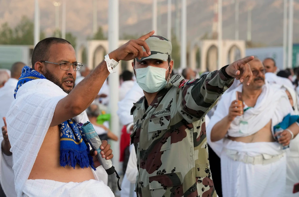 A Saudi police officer guides a pilgrim on the way to Mount Arafat. (AP)