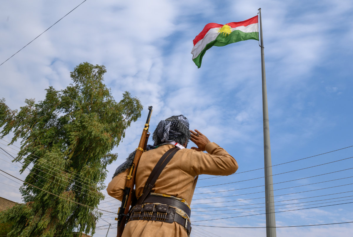 A Kurdish Peshmerga salutes the Kurdish flag in Arbil, in Iraq's Kurdish autonomous region. (AFP)