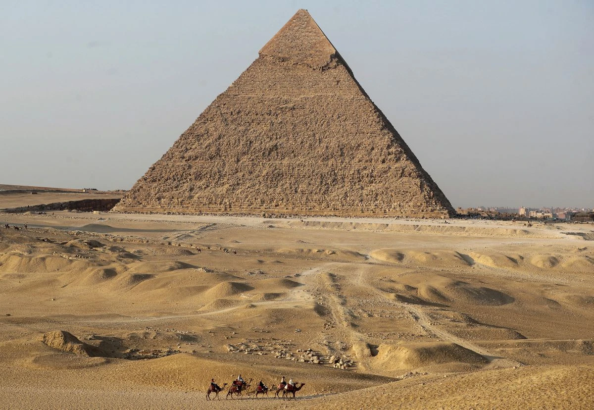Tourists ride camels in front of the Great Pyramids. (Reuters)