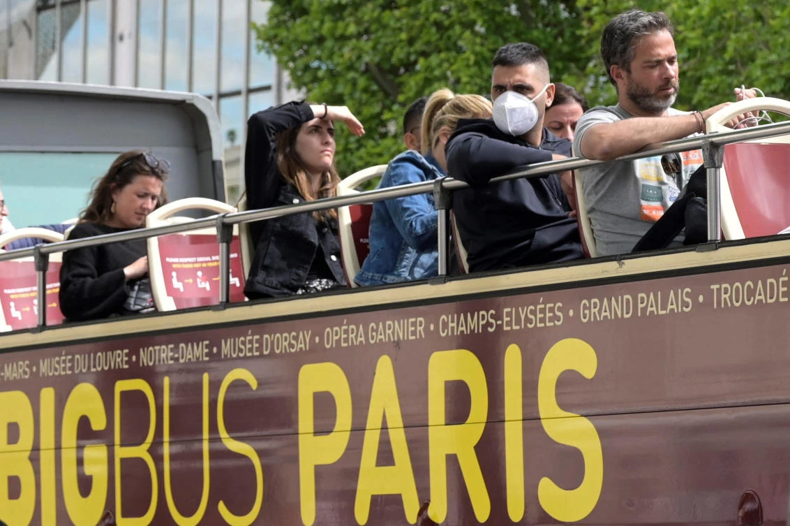 A man wears a protective mask against Covid-19 as he rides on the open deck of a double-decker tourist bus in Paris, on Friday. (AFP)
