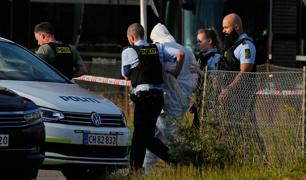 A person in a white DNA suit is taken away by the police, near the Field's shopping center, after a shooting, in Copenhagen, Denmark, Sunday July 3, 2022. (AP)