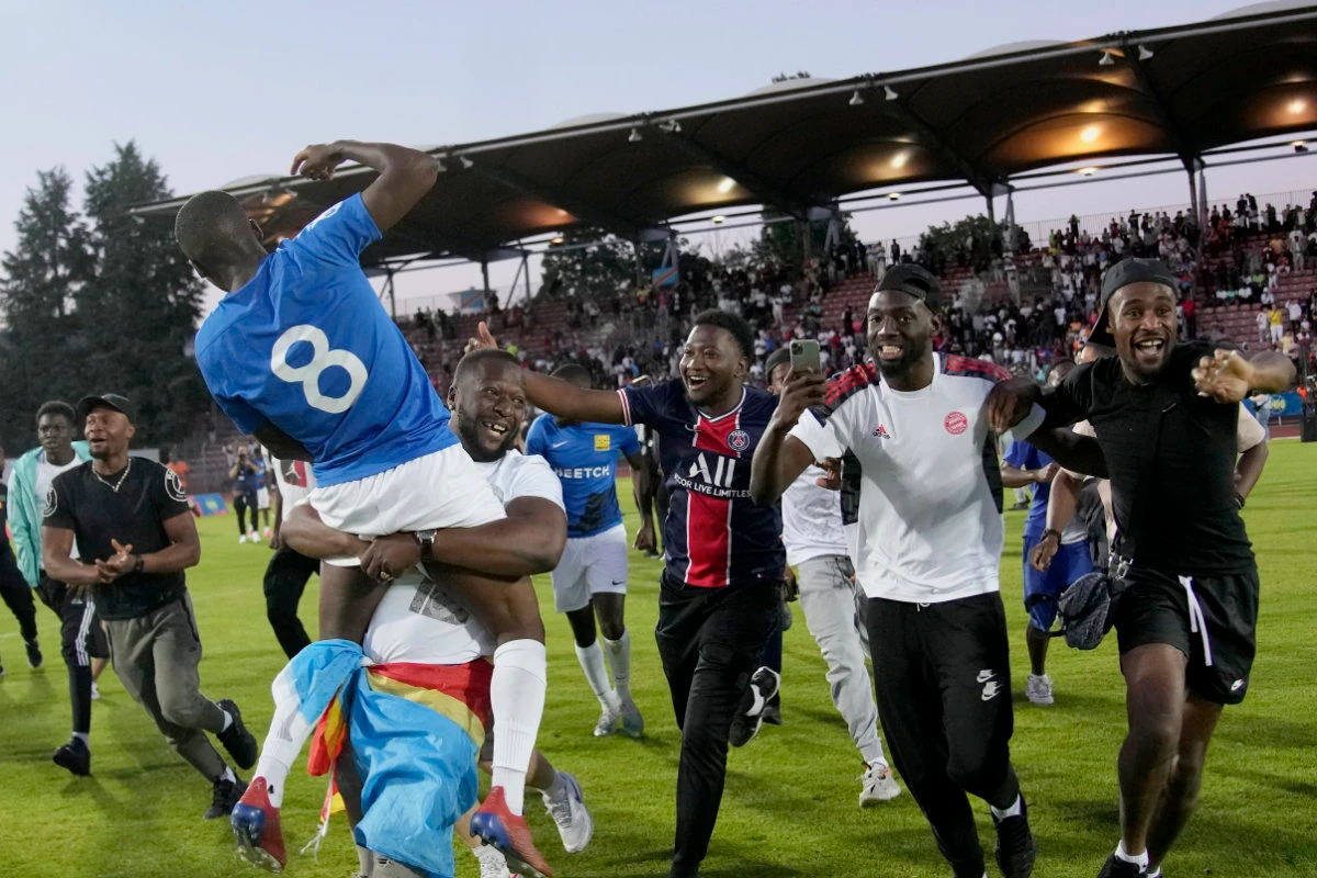 Congolese fans enter the pitch after Congo defeated Mali during the final game of the national cup of working-class neighborhoods in Creteil, outside Paris, France, on June 2, 2022. (AP)