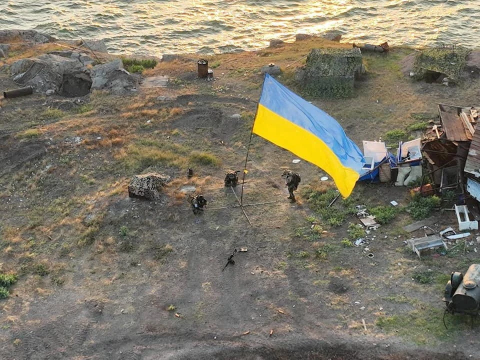 Ukrainian service members install a national flag on Snake Island in this handout picture released July 7, 2022. (Press service of the Ukrainian Armed Forces via Reuters)
