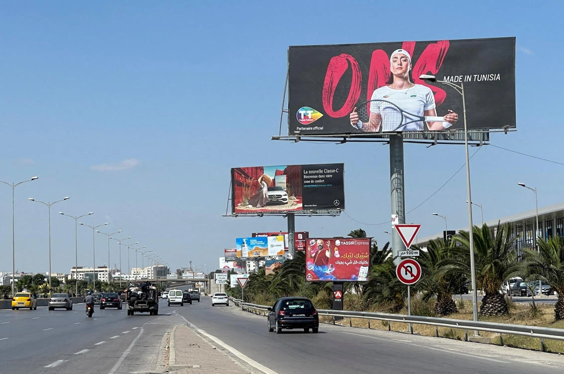 Vehicles drive past a billboard depicting Tunisian tennis player Ons Jabeur in Tunis, on Friday. (Reuters)
