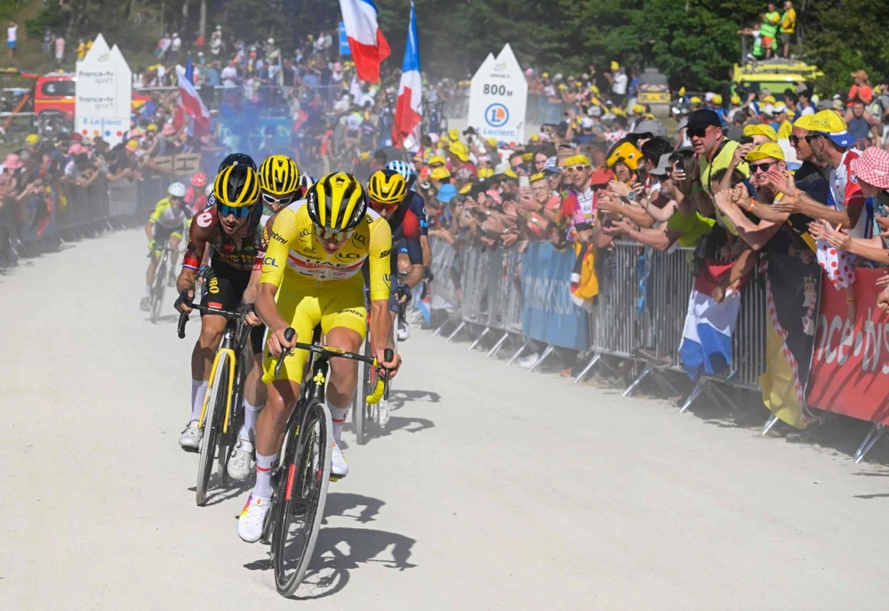 UAE Team Emirates team’s Slovenian rider Tadej Pogacar wearing the overall leader’s yellow jersey (C) cycles in the final kilometers to win the 7th stage of the 109th Tour de France cycling race. (AFP)