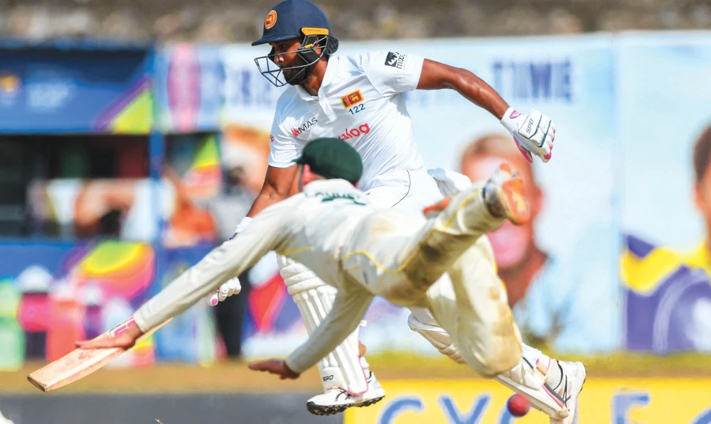 Sri Lanka’s Dinesh Chandimal, right, runs between the wickets during the match between Sri Lanka and Australia, in Galle on Sunday. (AFP)