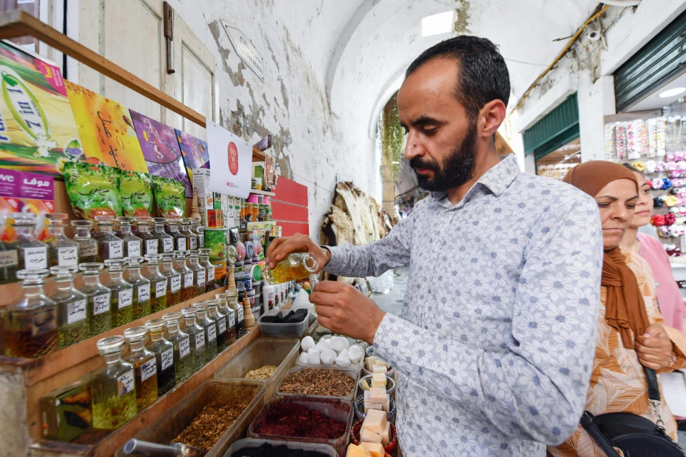 Tunisian perfumer Zouhaier Ben Abdallah blends jasmine extracts at his bazaar shop in the Old City of Tunis. (AFP)