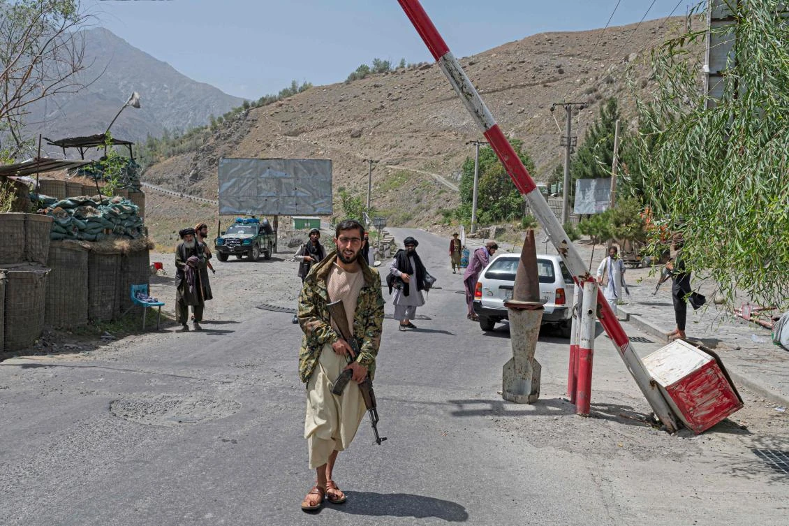 This photo taken on July 8, 2022 shows Taliban fighters searching vehicles at a checkpoint of Bazarak district, Panjshir province. (AFP)