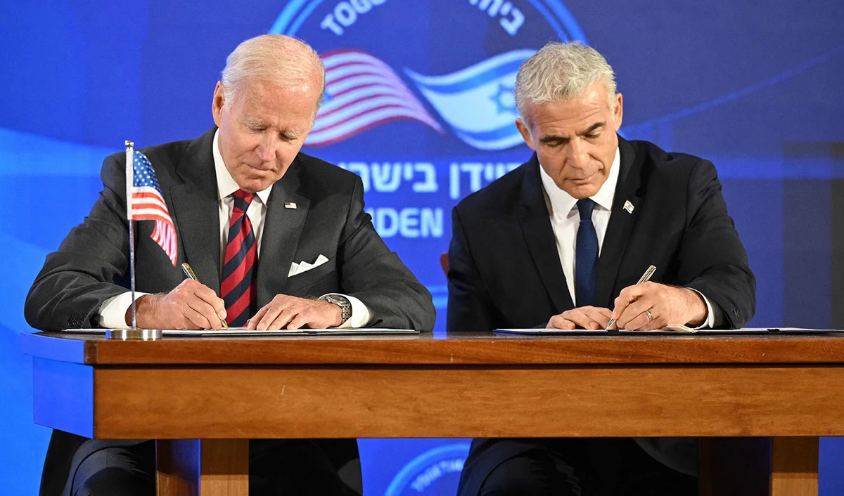US President Joe Biden, left, and Israel's caretaker Prime Minister Yair Lapid, sign a security pledge in Jerusalem, on July 14, 2022. (AFP)