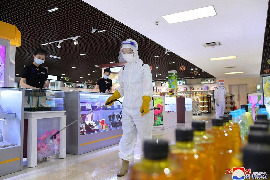 Above, a safety staff disinfects a shop in Pyongyang to prevent the spread of the COVID-19 on July 2, 2022. (KCNA via KNS/AFP)