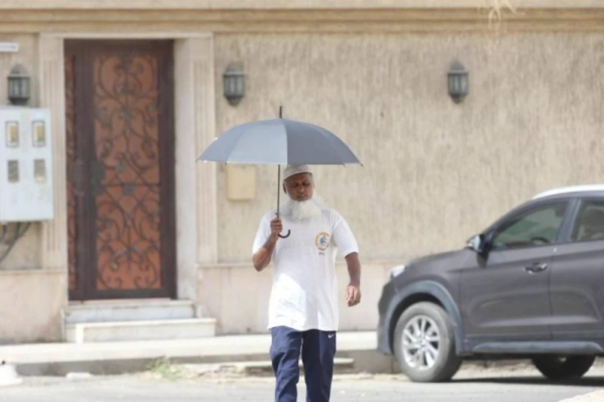 A man uses an umbrella to protect himself from the scorching heat. (Supplied)