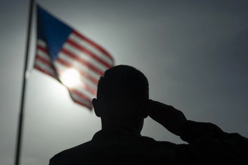 Above, a US soldier salutes the flag at Camp Simba in Kenya. AFRICOM maintains military relations with all African nations except Egypt. (US Air Force/AFP)