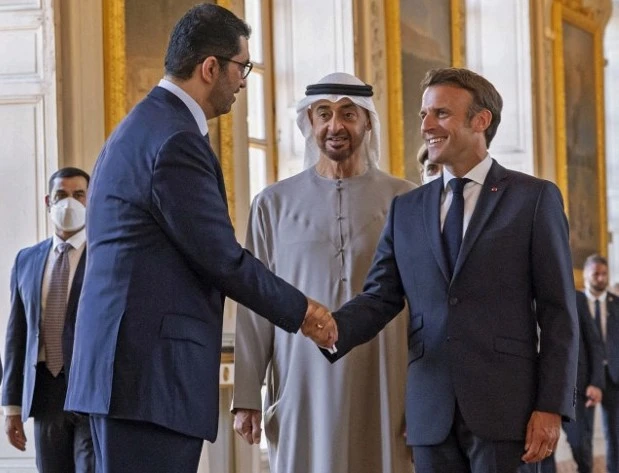 France's President Emmanuel Macron (R) greeting UAE's Industry Minister Sultan Ahmed Al-Jaber in the presence of UAE's President Sheikh Mohamed bin Zayed Al-Nahyan (C) during a reception dinner at the Grand Trianon in Versailles on July 18, 2022. (AFP)