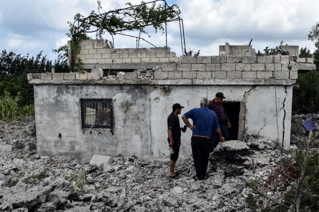 Residents assess the damage caused to a building in the western Syrian coastal city of Tartus after an earlier Israeli air strike early July. A war monitor claims Israel has hit Syrian territory 17 times this year. (AFP)