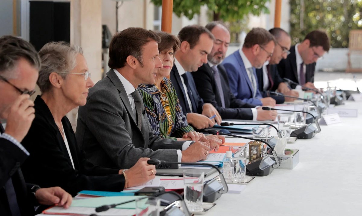 French President Emmanuel Macron is flanked by French prime minister and foreign minister, as he leads a meeting with members of the Paris 2024 Olympic and Paralympic Games Organizing Committee at the Elysee Palace in Paris on July 25, 2022. (Reuters)