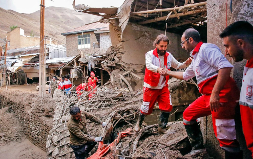 A rescue team works at the site of a flash flood in the northwestern part of Tehran. The Red Crescent has warned people to avoid rivers and mountainous areas. (AFP)
