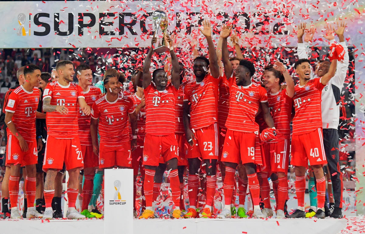 Bayern Munich's Sadio Mane celebrates winning the DFL Super Cup with the trophy and teammates. (Reuters)