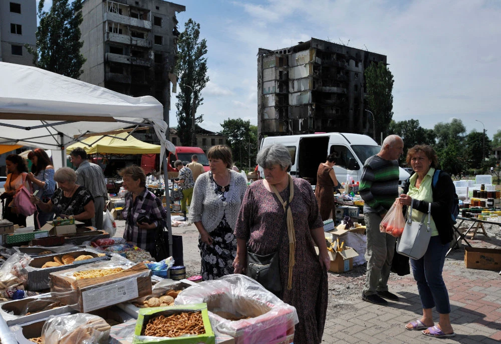 People wander at a makeshift market in the town of Borodianka, near Kyiv on July 7, 2022. (AFP)