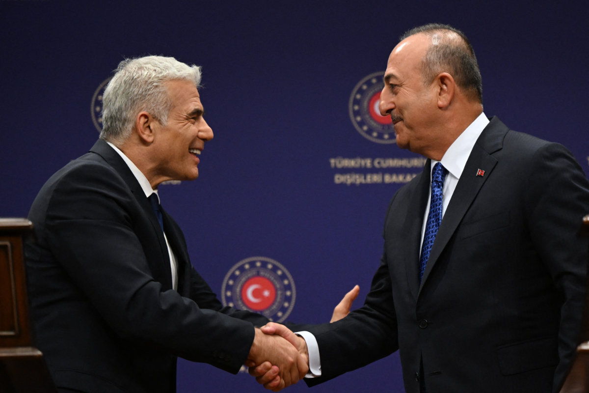 Turkish FM Mevlut Cavusoglu (R) and then Israeli FM Yair Lapid, now PM, meeting in Ankara last month. (AFP)