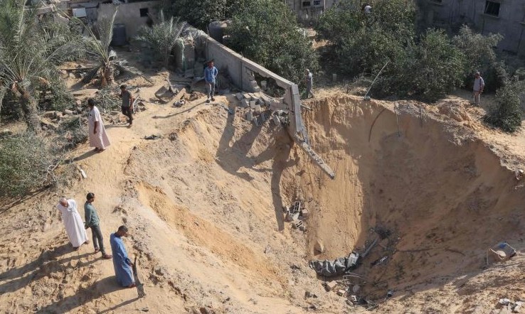 Palestinians inspect a crater, after three days of conflict with Israel, Rafah town, southern Gaza Strip, Aug. 8, 2022. (AFP)