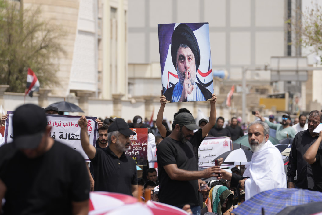 Supporters of Shiite cleric Muqtada Al-Sadr with his poster gather near the parliament building in Baghdad, Aug. 26, 2022. (AP)