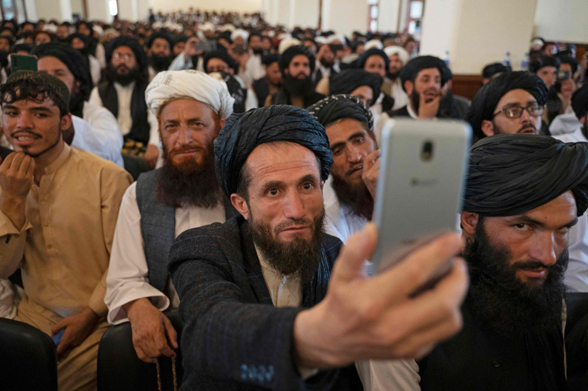 A Taliban member takes photos with his smart phone during a gathering in Kabul on Aug. 13, 2022. (AFP)