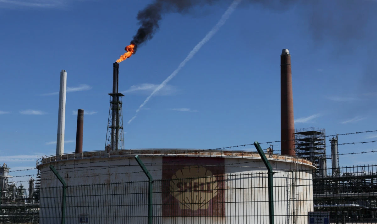 An oil tank of Shell is seen as a pilot flame burns atop a flare stack at the refinery of the Shell Energy and Chemicals Park Rheinland in Godorf near Cologne, Germany, August 3, 2022. (Reuters)