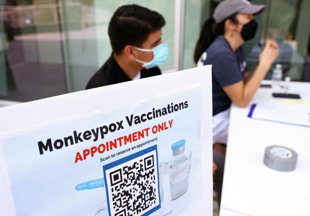 Health workers sit at a check-in table at a pop-up monkeypox vaccination clinic which opened today by the Los Angeles County Department of Public Health at the West Hollywood Library in West Hollywood, California. (AFP)
