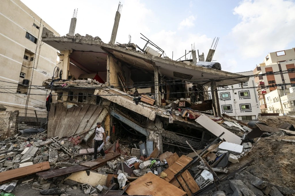 Palestinians salvage belongings from the rubble of their home, following Israeli air strikes in Gaza City, on August 7, 2022. (AFP)