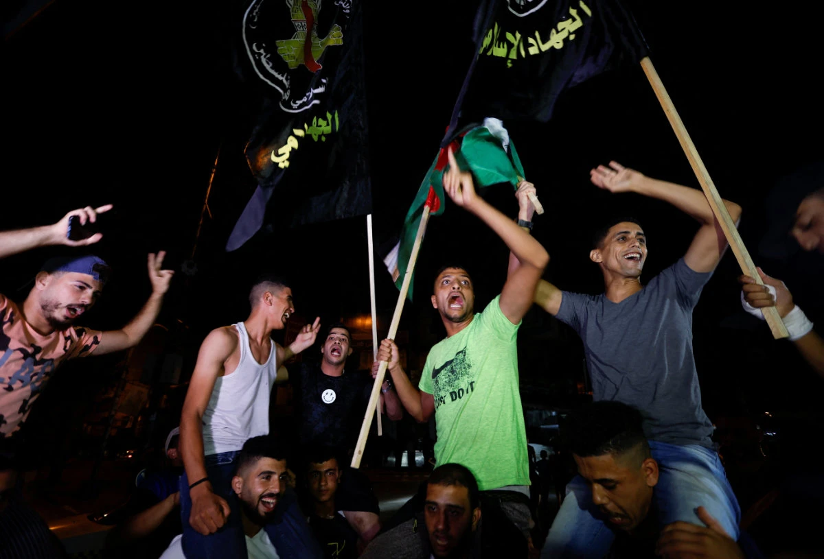 Palestinians celebrate on a street in Gaza City early Monday after a ceasefire between Israeli and Islamic Jihad forces was announced. (REUTERS/Ibraheem Abu Mustafa)