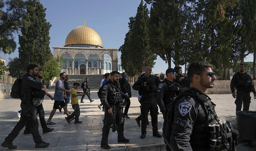 Israeli police officers escort a group of Jewish men visiting the Temple Mount, known to Muslims as the Noble Sanctuary, on the Al-Aqsa Mosque compound in the Old City of Jerusalem on Aug. 7, 2022. (AP)
