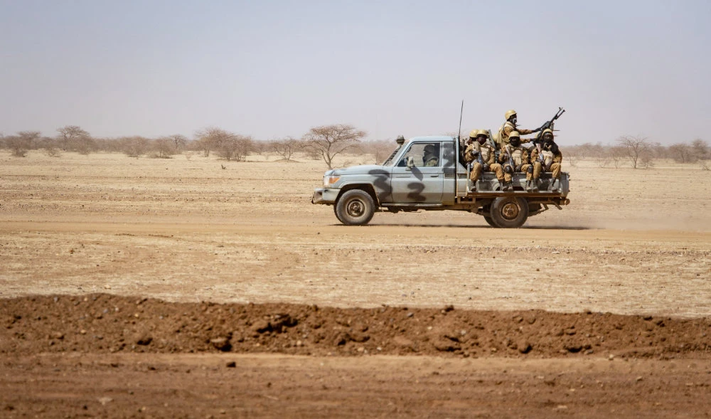 Burkina Faso soldiers patrol aboard a pick-up truck on the road from Dori to the Goudebo refugee camp. (AFP)