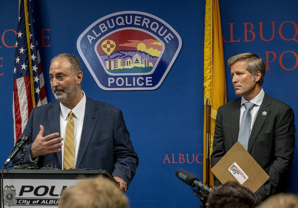 Ahmad Assed, president of the Islamic Center of New Mexico, left, speaks at a news conference to announce the arrest of Muhammad Syed as Albuquerque Mayor Tim Keller listens. (The Albuquerque Journal via AP)