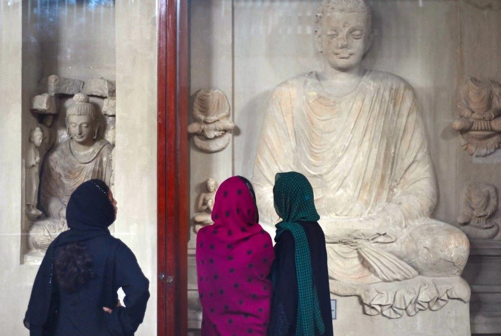 Pakistani women look at statues of Buddha on display in a museum at Taxila in Punjab province on April 3, 2012. (AFP)