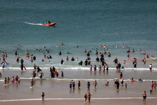 People swimming in the sea at Perranporth beach, in Perranporth, Cornwall, Britain, on Jul.18, 2022. (Reuters)