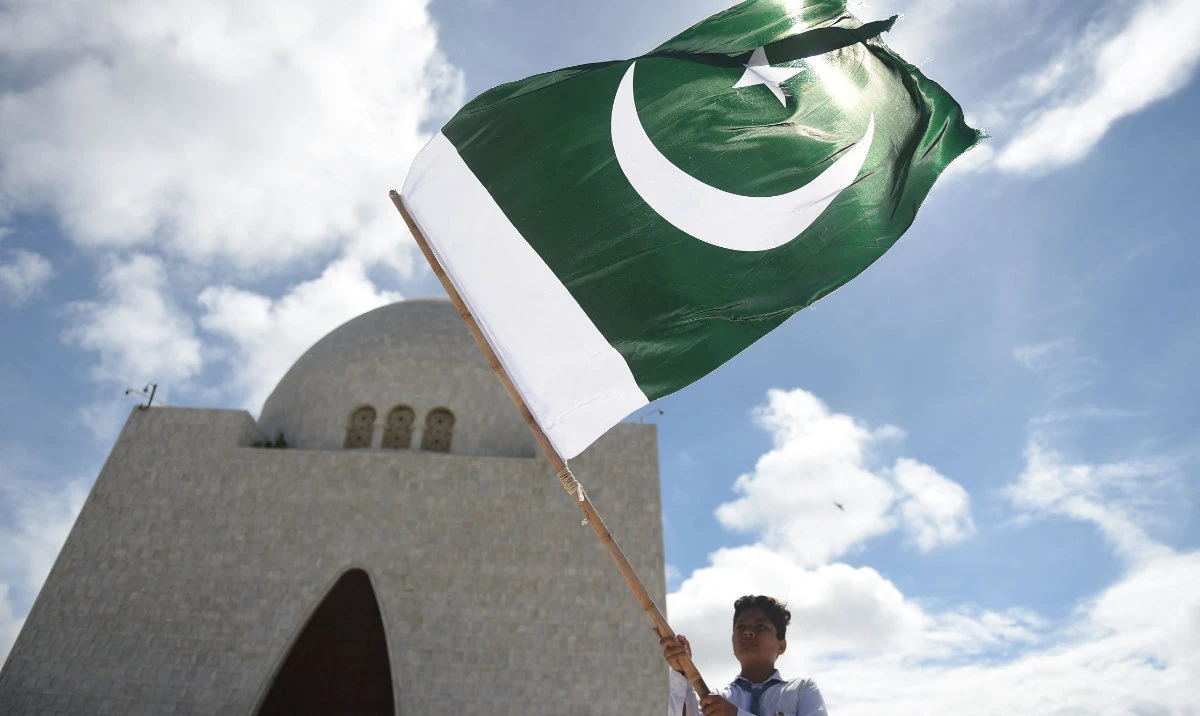 A student waves the national flag of Pakistan outside the mausoleum of Mohammed Ali Jinnah during the country's 75th Independence Day ceremony in Karachi. (AFP)