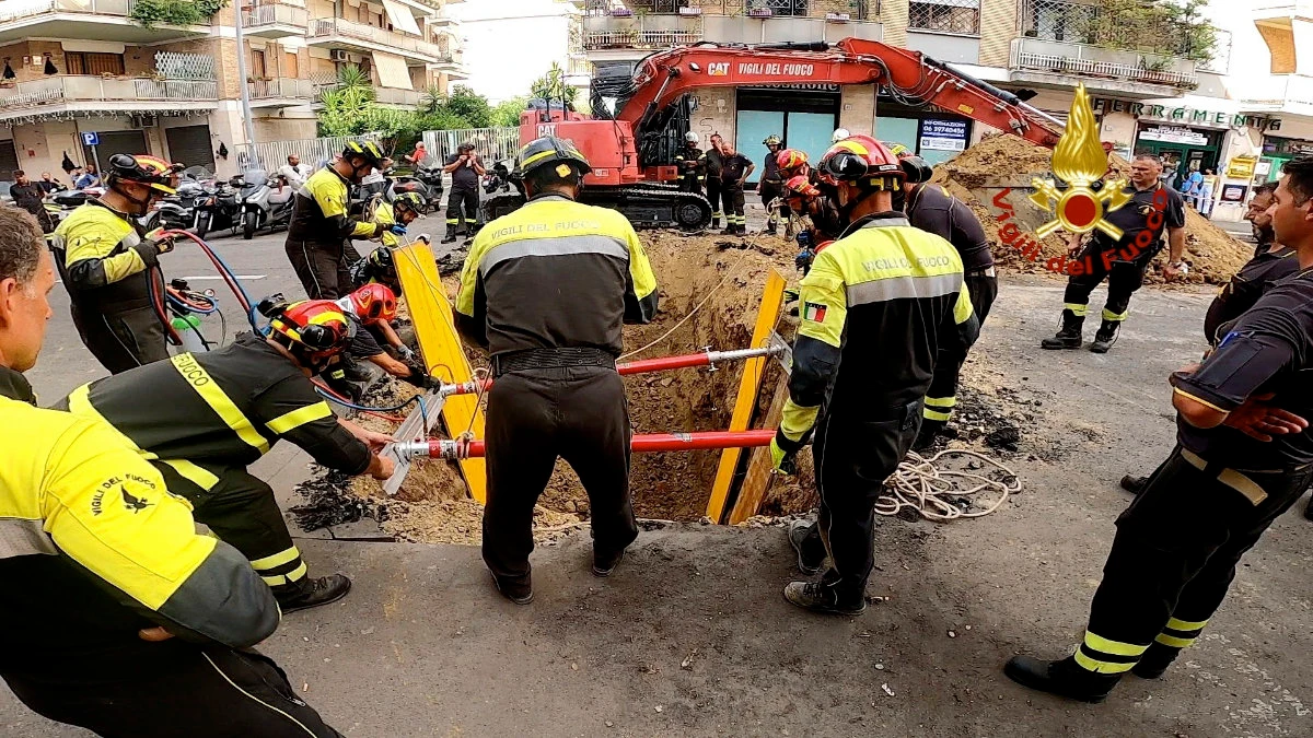 Italian firefighters dig up the road to rescue a man blocked in a tunnel in Rome on Aug. 11, 2022. (Italian Firefighters Via AP)