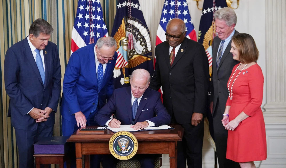 US President Joe Biden signs the Inflation Reduction Act of 2022 into law during a ceremony in the State Dining Room of the White House in Washington, DC, on August 16, 2022. (AFP)