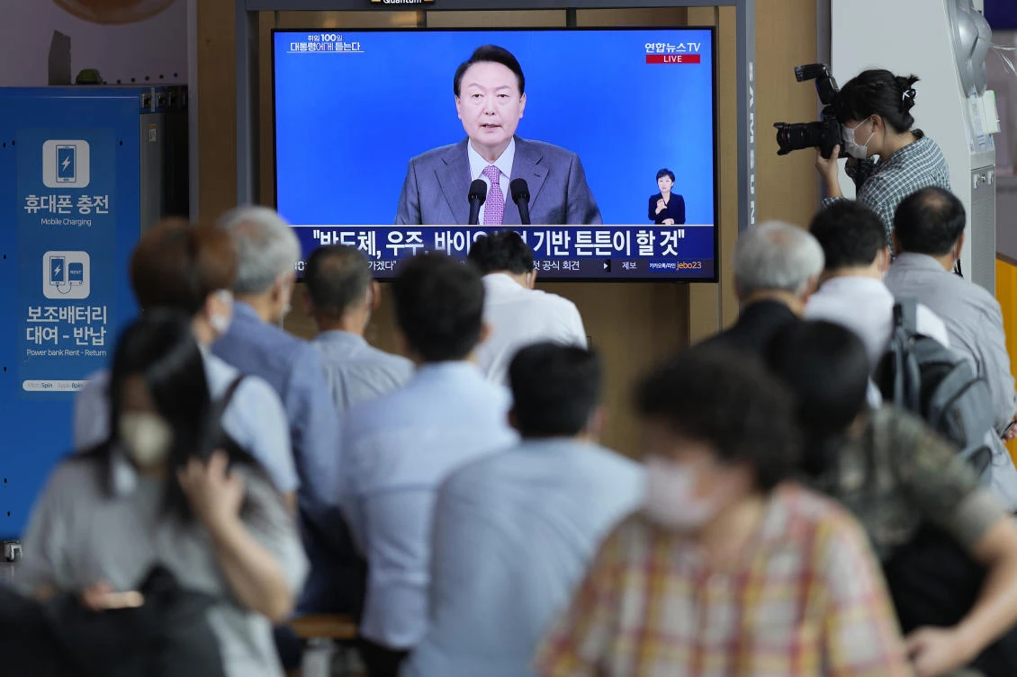 Residents watch South Korean President Yoon Suk-yeol watch his wide-ranging press conference to mark his first 100 days in office in Seoul on Aug. 17, 2022. (AP)
