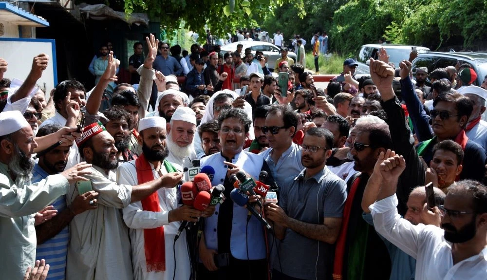 Faisal Javed, Pakistan Tehreek-e-Insaf (PTI) party politician, makes a statement as supporters of former Pakistan PM Imran Khan gather outside his home, Islamabad, Pakistan, Aug. 22, 2022. (Reuters)