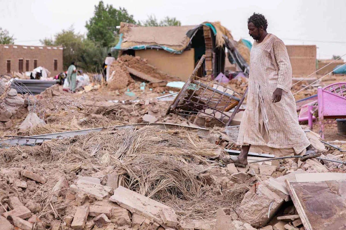 A man walks past the remains of a destroyed mudbrick house following floods in the village of Makaylab in Sudan's Nile River State on August 19, 2022. (AFP)