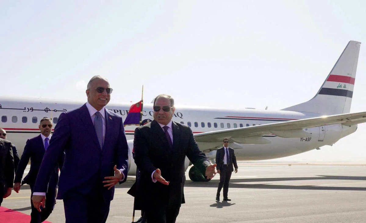 An image released by the press office of Iraqi Prime Minister shows Egypt’s President Abdel Fattah El-Sisi receiving prime minister Mustafa Al-Kadhemi upon landing in Egypt’s city of El-Alamein, on August 22, 2022. (AFP)