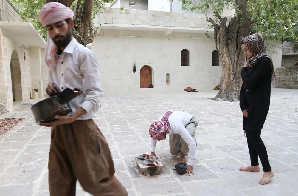 Yazidi woman Ashwaq Haji (R), allegedly used by the Daesh group as a sex slave, visits the Lalish temple in Kocho near Sinjar, northern Iraq, on August 15, 2018. (AFP)