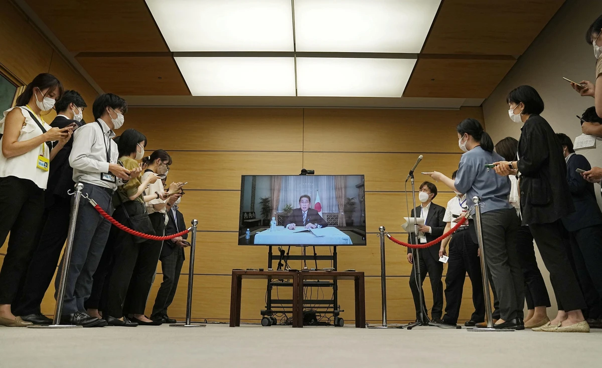 Japan’s Prime Minister Fumio Kishida is seen on a screen as he answers remotely to questions from reporters after he tested positive for COVID-19 the previous day at his residence in Tokyo, Japan on Aug. 22, 2022. (Kyodo via Reuters)