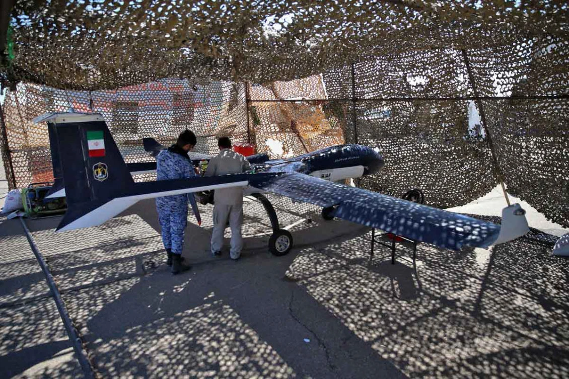 Technicians inspect a military unmanned aerial vehicle in a camouflage enclosure during a two-day drone drill at an undisclosed location in Iran. (Iranian Army office via AFP)